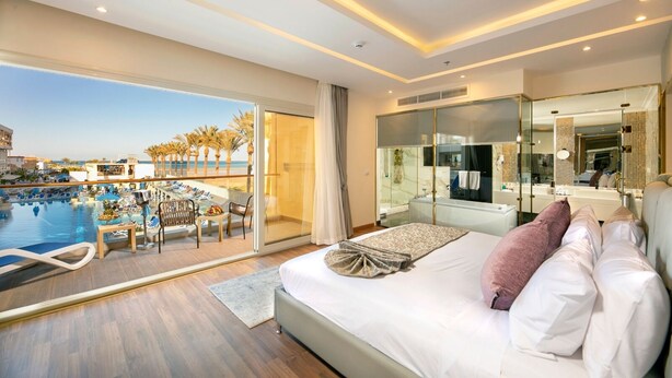 Una camera d'albergo con un letto, vista sulla piscina e un balcone.