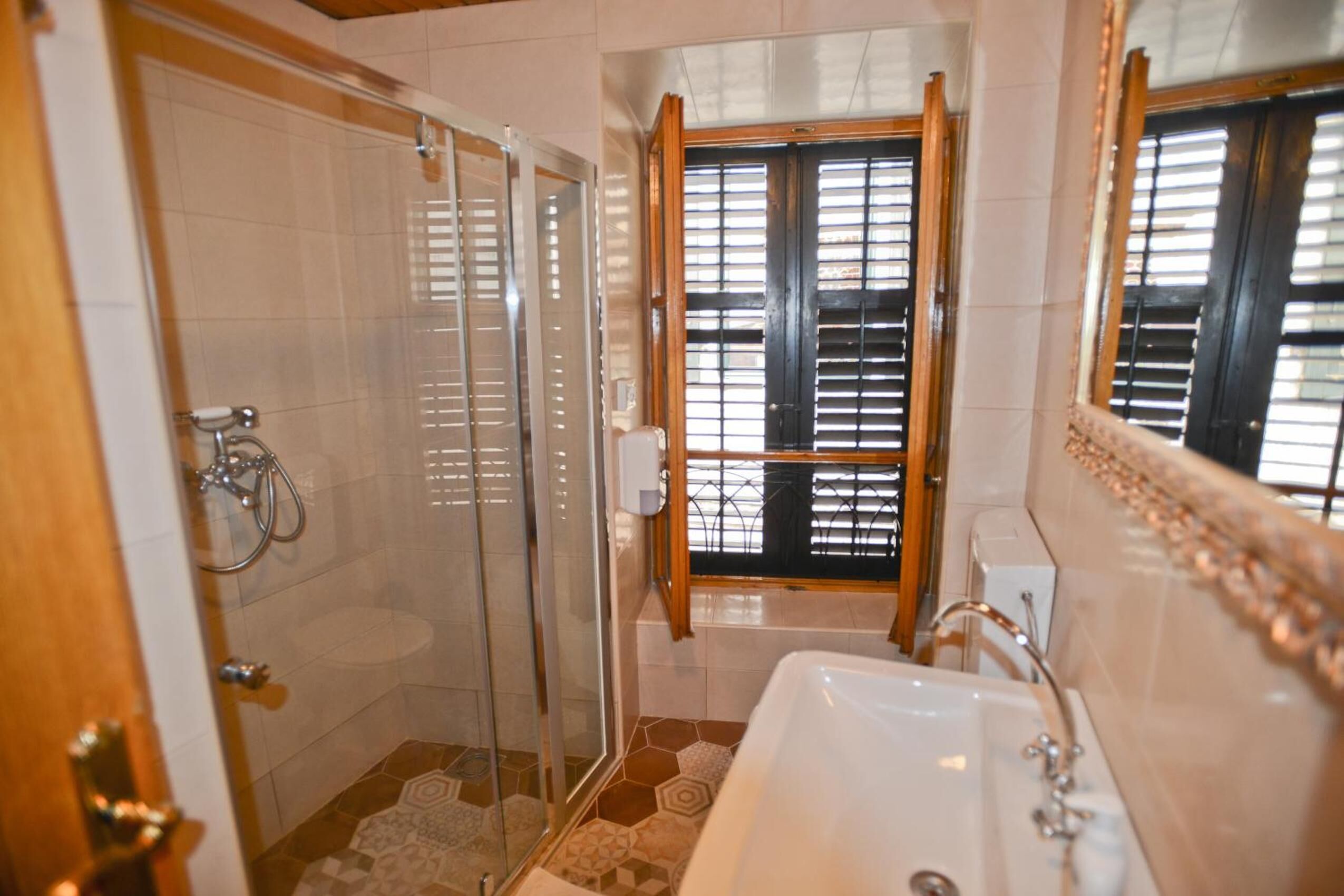Une salle de bain avec une douche à parois de verre, une baignoire et un lavabo.