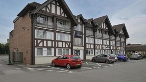 A row of traditional half-timbered buildings with a sign for 'Travelodge.' - Travelodge Birmingham Sheldon (Birmingham)