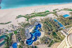 An aerial view of a resort with a large pool, beach area, and palm trees. - Waldorf Astoria Ras Al Khaimah (Ras Al Khaimah)