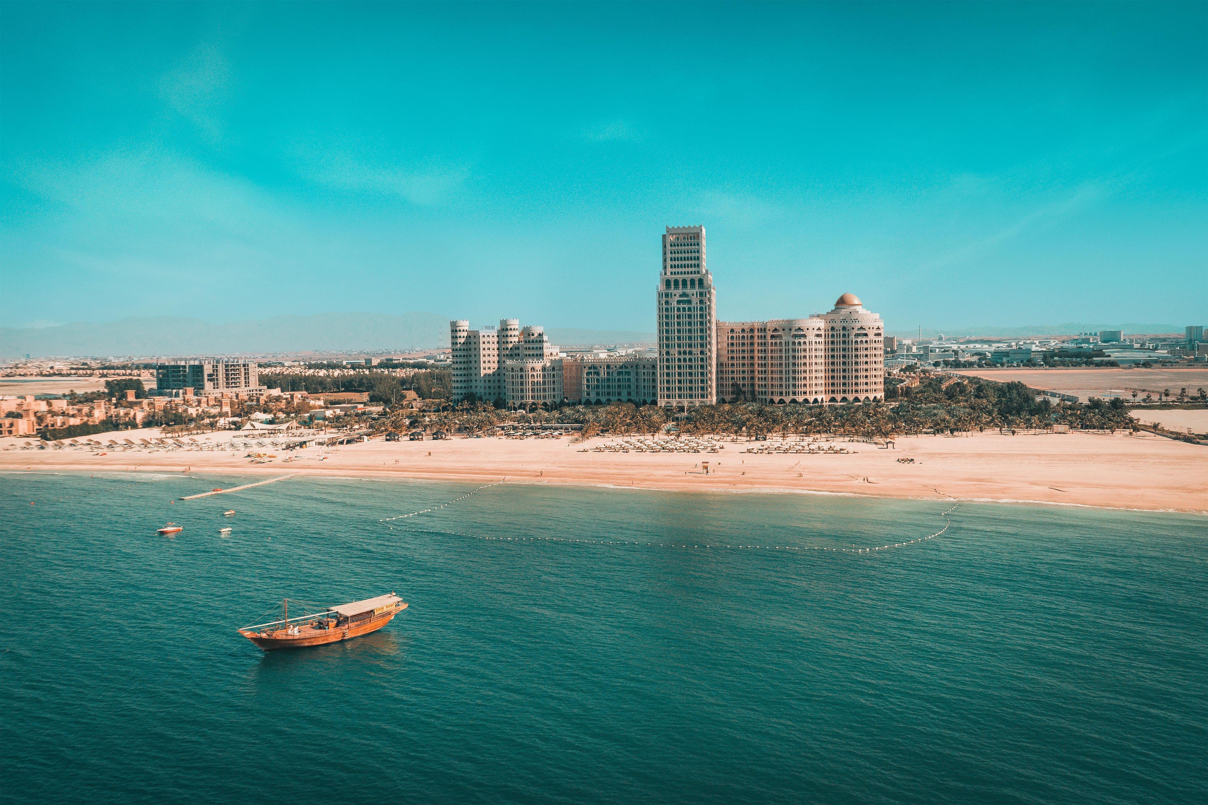 Un paisaje urbano costero con una torre destacada y una playa.