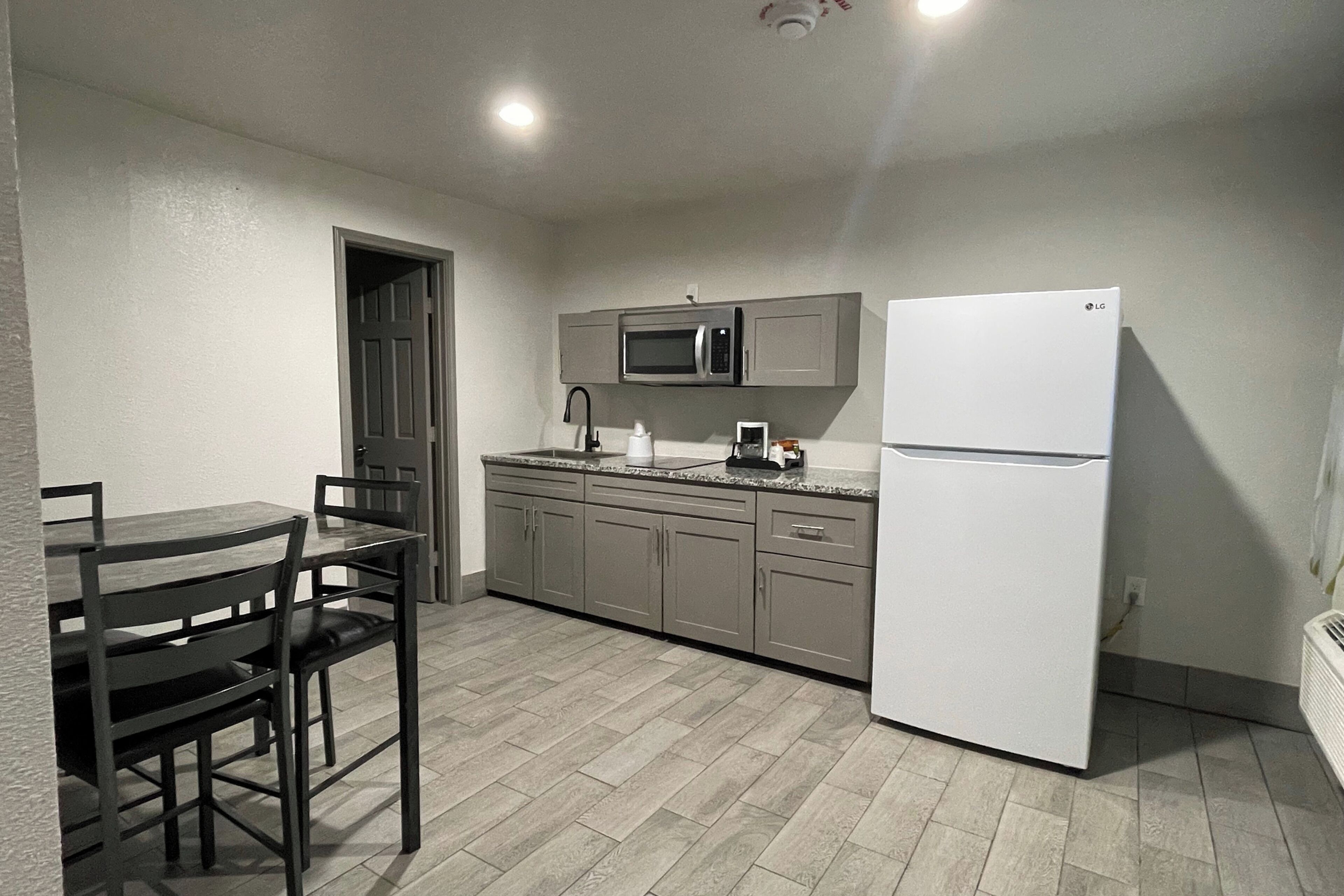 A compact kitchen with a microwave, refrigerator, and dining area.
