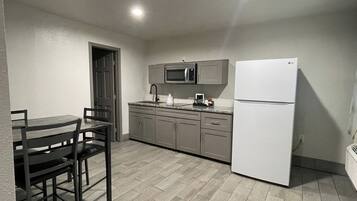 A compact kitchen with a microwave, refrigerator, and dining area.