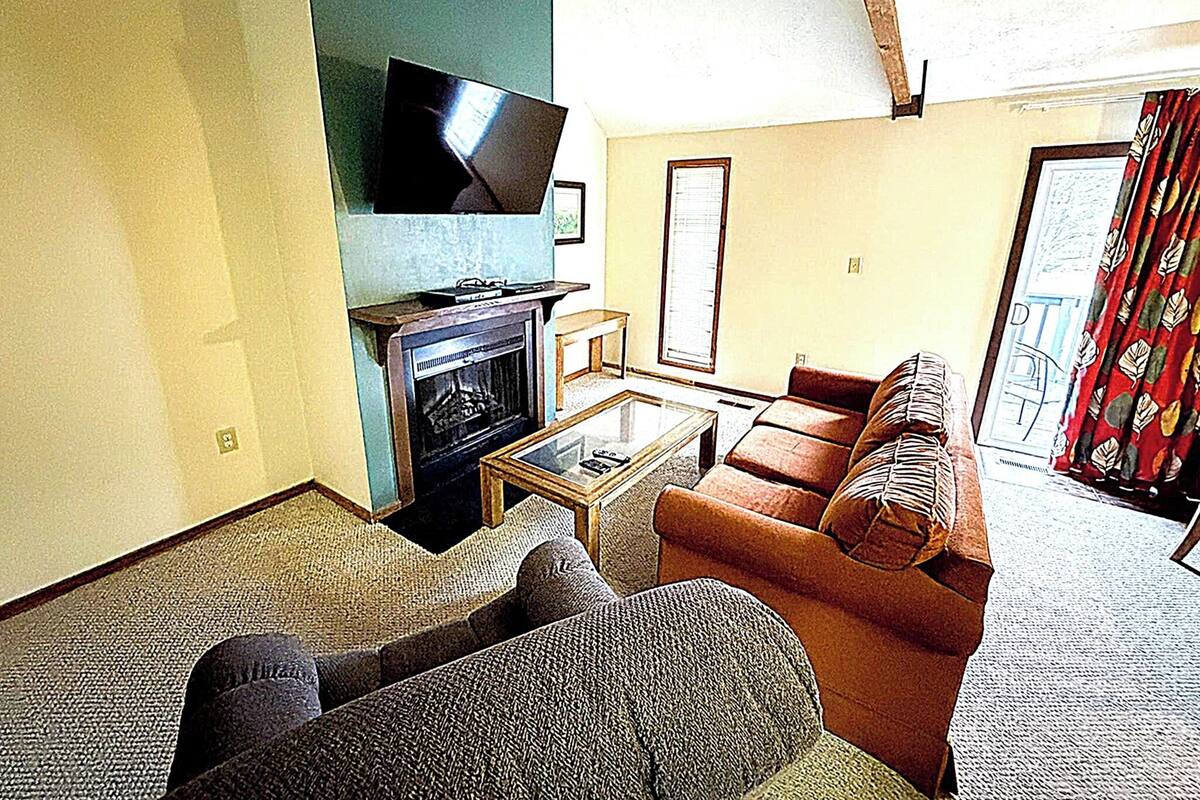 A living room with a fireplace, a television, a sofa, and a coffee table.