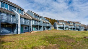 A row of modern multi-story residential buildings with balconies and a grassy front yard. - Chalet High by Coolvacay (Basye)