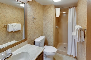 Un baño con lavamanos, inodoro y ducha.