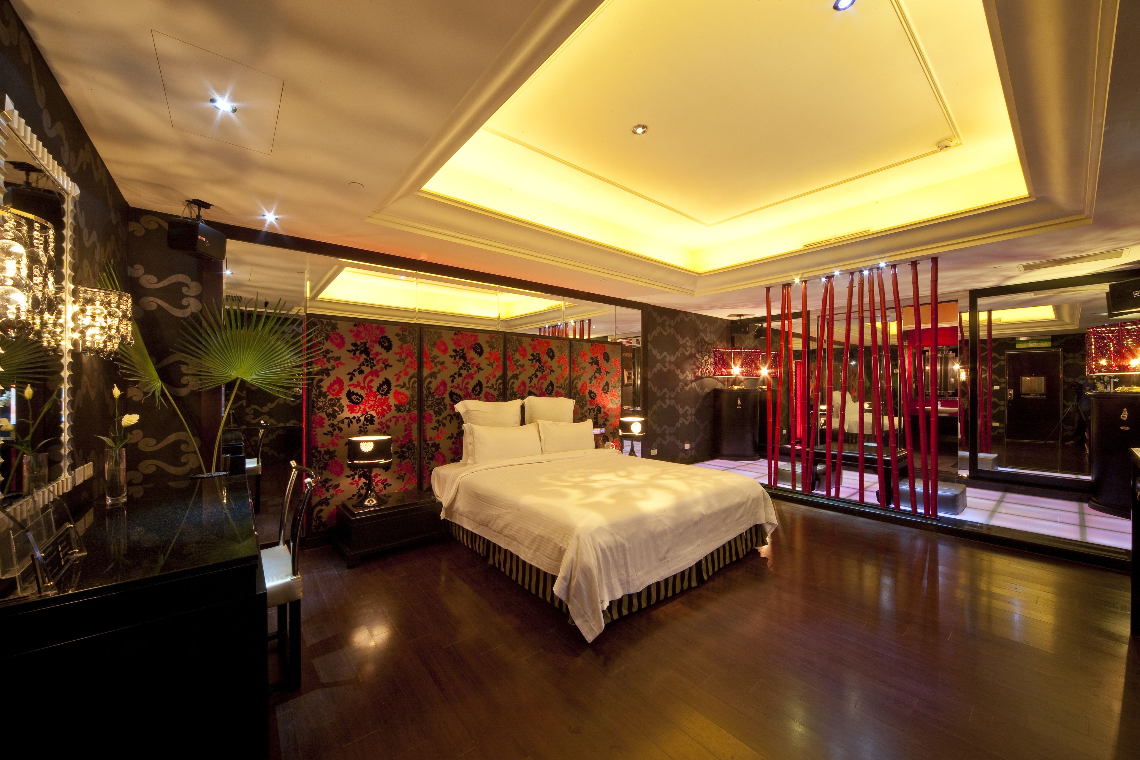 A modern bedroom with a large bed, a vanity with a mirror, and a nightstand.