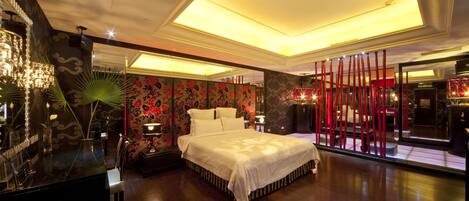 A modern bedroom with a large bed, a vanity with a mirror, and a nightstand.
