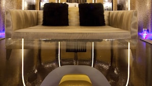 A luxurious room with a reflective floor, a plush sofa, and ambient lighting. - Wego Boutique Hotel Linsen (Taipei)