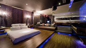A modern hotel room with a large bed, a seating area, and a bathroom with a large mirror and sink. - Wego Boutique Hotel Linsen (Taipei)