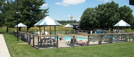 Una piscina al aire libre de temporada, sombrillas