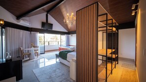 Une chambre moderne avec un lit, un bureau et une chaise. On y trouve une fenêtre avec des rideaux, un lustre et une cloison en bois.