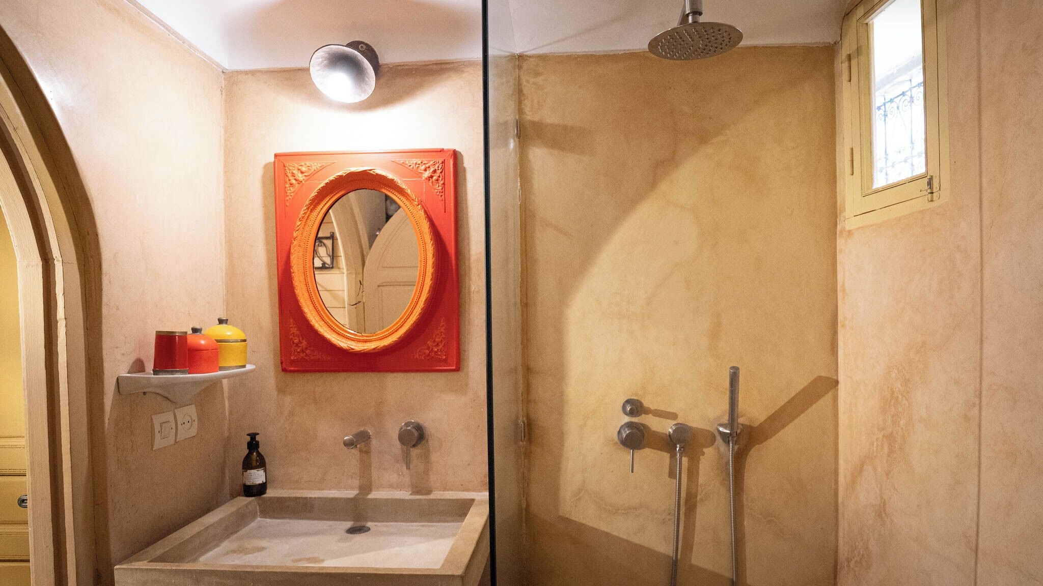 Un baño con lavamanos, espejo y ducha.