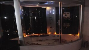Una habitación circular con cerramiento de vidrio, un panel de control y una estructura metálica.
