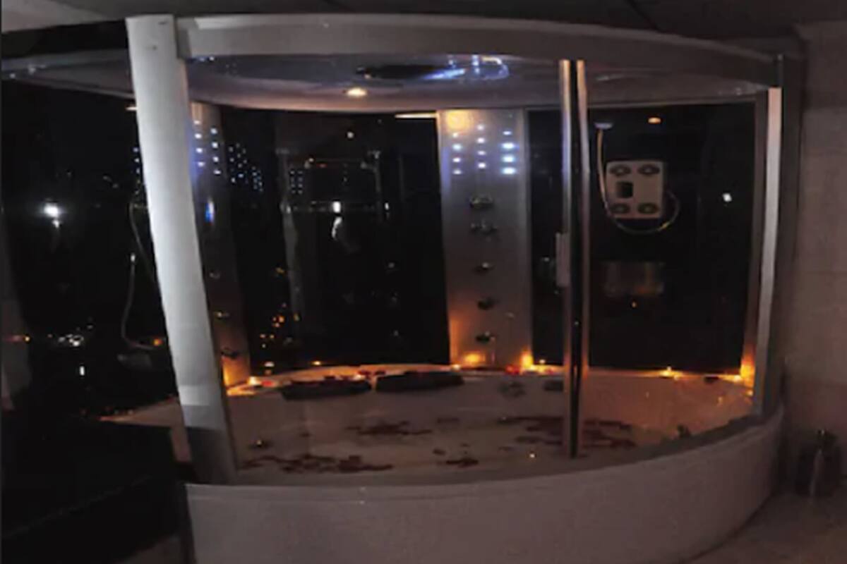A circular room with a glass enclosure, a control panel, and a metallic structure.