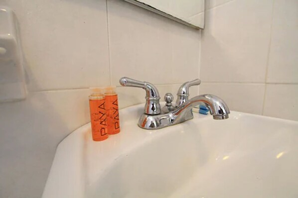 A bathroom sink with two bottles of Paxall mouthwash and a mirror above it.