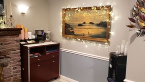 A room with a fireplace, a bookshelf, a coffee machine, and a water dispenser. - Jones Beach Hotel (Wantagh)