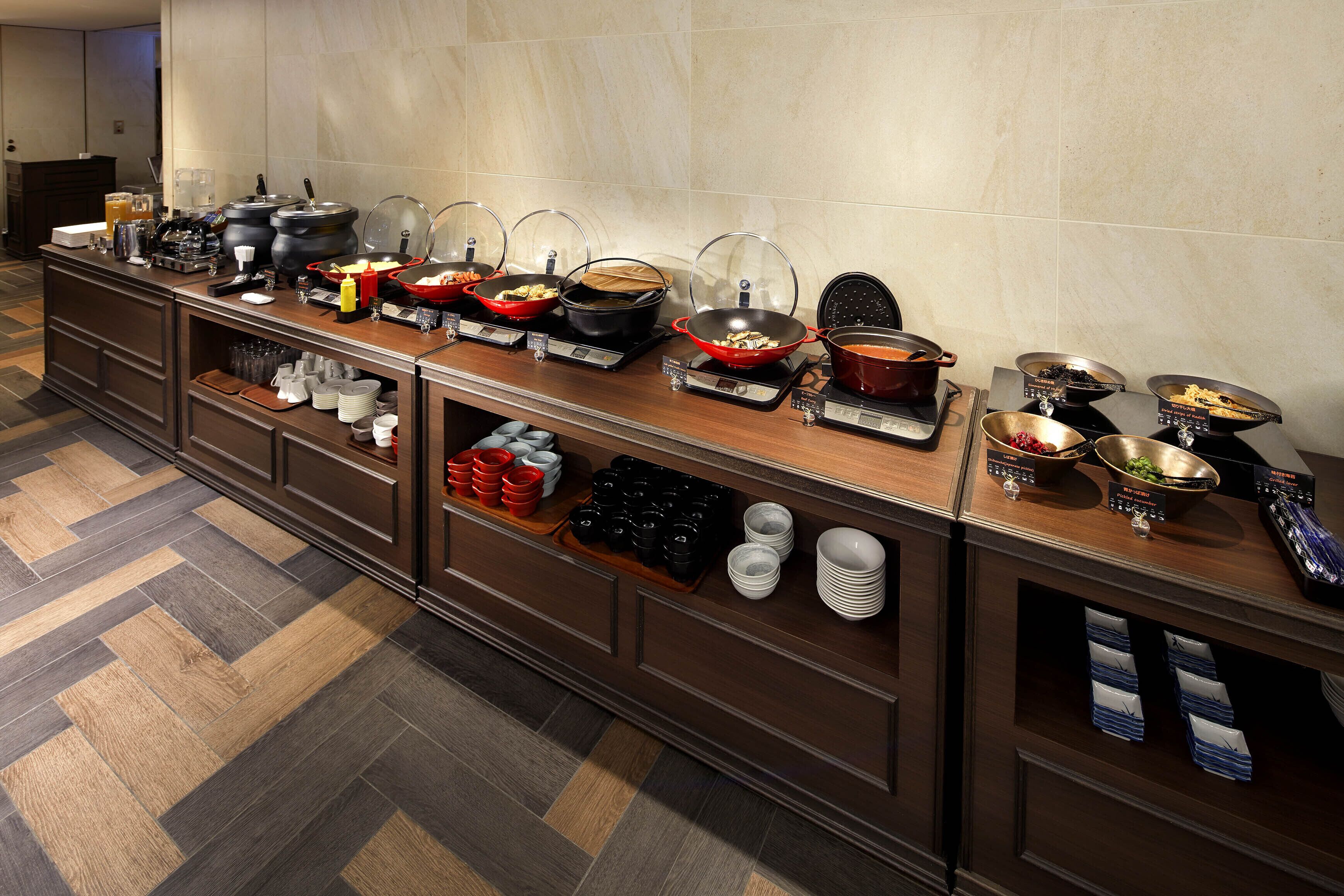 A buffet setup with various food items and condiments.