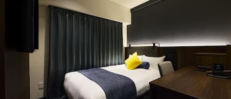 Une chambre d’hôtel avec un lit, un bureau, une chaise et un téléviseur.