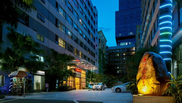 Un hôtel à étages, doté d’une entrée bien éclairée et d’une grande sculpture en pierre.