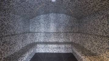 Unique mosaic design adorns the walls, ceiling, and floor, complemented by a curved bench for seating.
