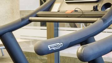 Un tapis de course doté d’un écran numérique et du logo TECHNOGYM.