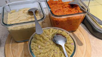 Three glass containers with different food items on a wooden board.