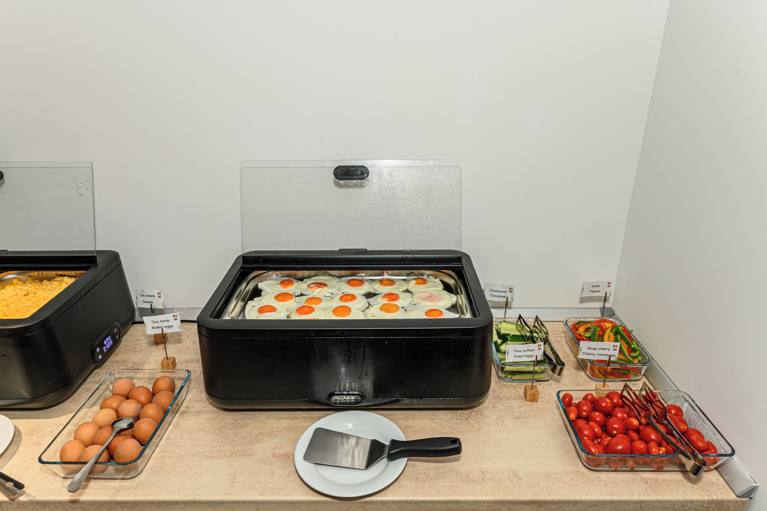 A buffet with various food items including boiled eggs, fried eggs, and tomatoes.