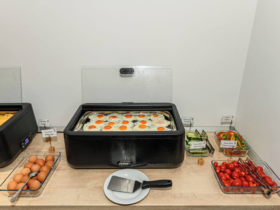 A buffet with various food items including boiled eggs, fried eggs, and tomatoes.