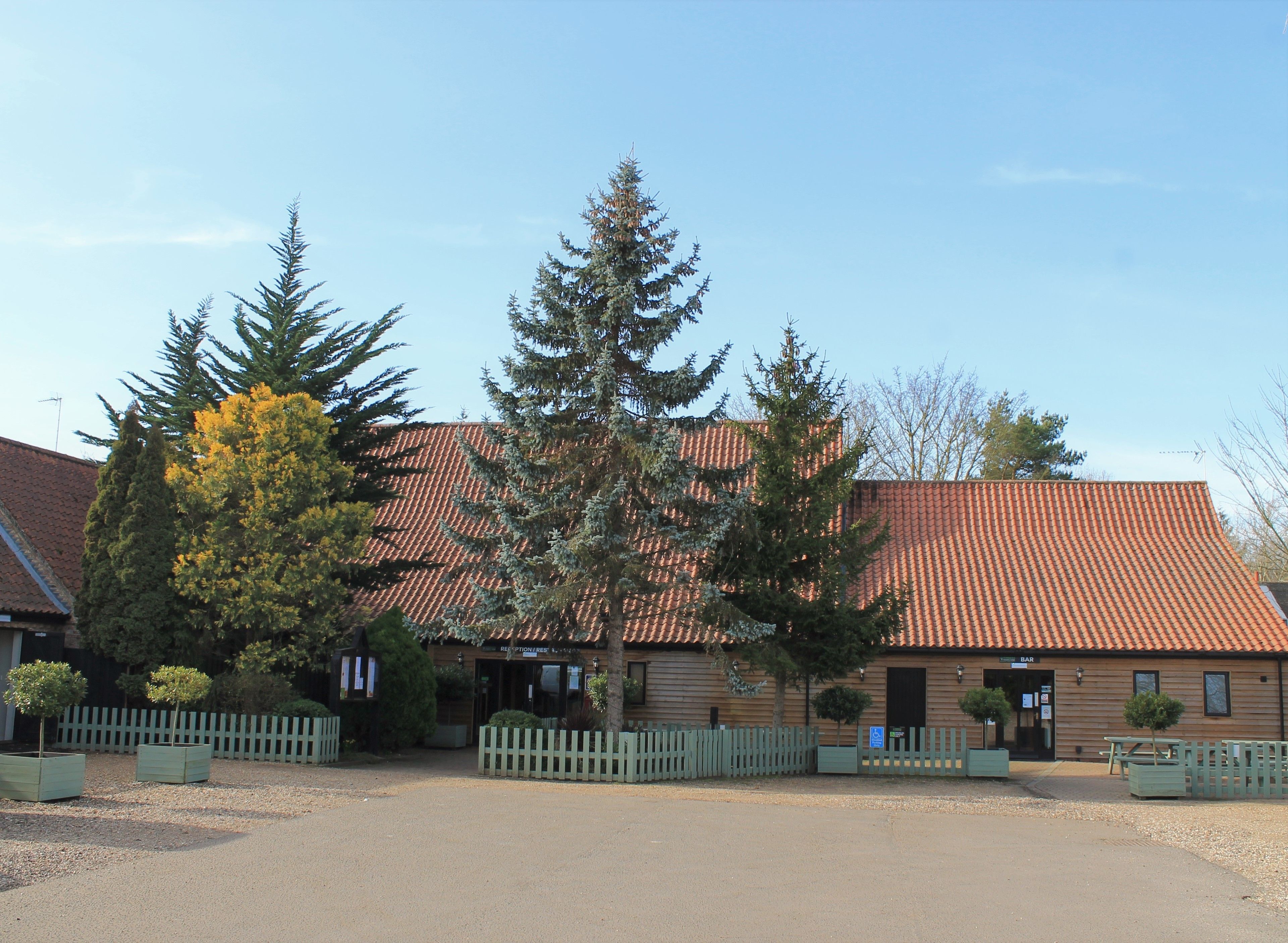 A building with a tiled roof, a reception desk, and a sign for a bar.