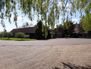 A building with a gravel driveway and a fenced parking area.
