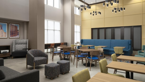 Un intérieur moderne avec un canapé bleu, des tables en bois et des chaises à motifs.