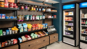 Un présentoir proposant divers aliments emballés, une section réfrigérée et un panneau bleu indiquant la section des produits surgelés.