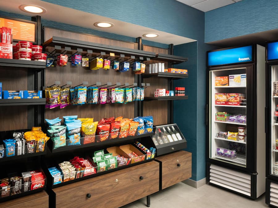 En udstilling med snacks og forskellige mærker, samt en kølet sektion med drikkevarer.