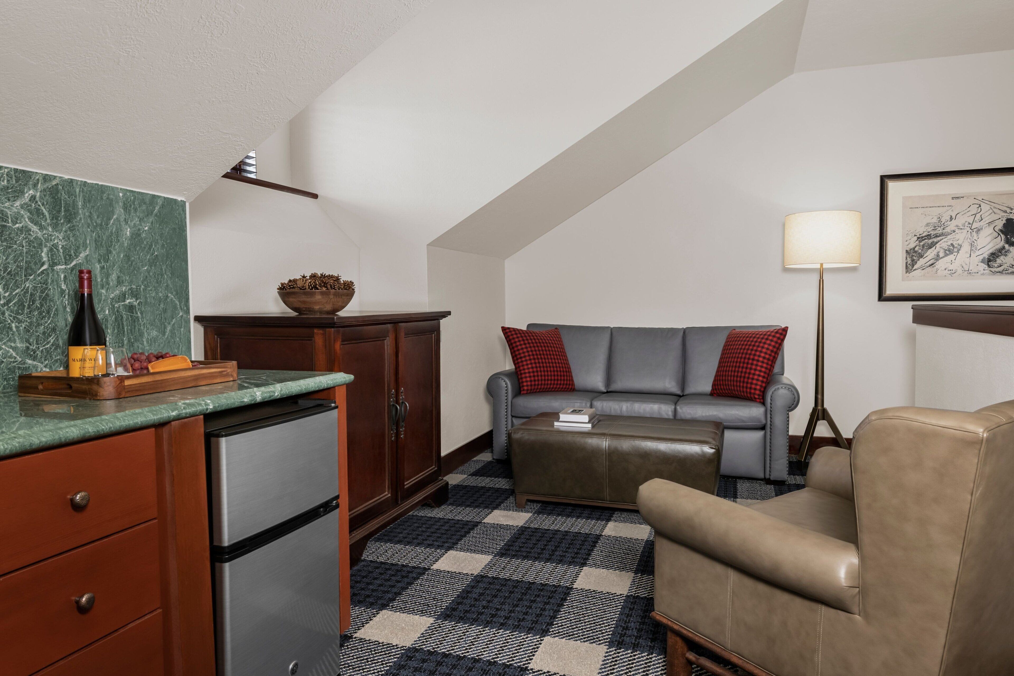 A compact living space with a kitchen area, a sofa, a coffee table, and a lamp.