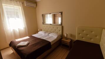 Una camera d'albergo con un letto, un comodino e uno specchio.