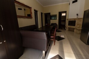 A modern kitchen with a dining area, a fireplace, and a TV mounted on the wall. - Bella Villa Siofok (Siófok)