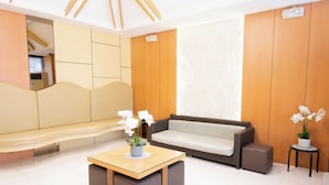 Una sala de estar moderna con un sofá, una mesa de centro y una mesita con flores.