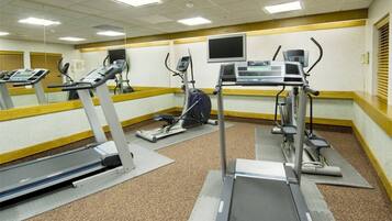 Une salle de sport équipée de tapis de course, d’appareils elliptiques et de vélos d’appartement.