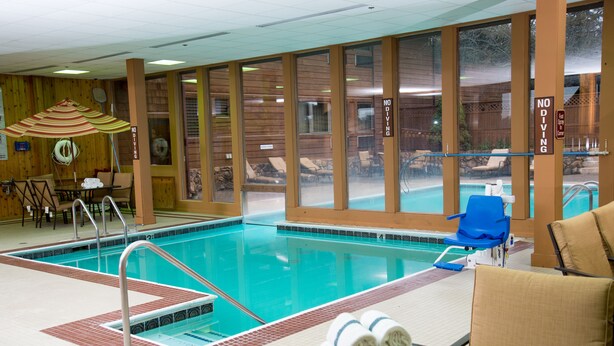 Ein Hallenbad mit Liegestühlen und einem Tisch mit Handtüchern.