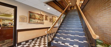 Una escalera con piso a cuadros que lleva a un restaurante.