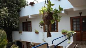 A multi-level building with balconies, potted plants, and a tiled floor. - Casa Mara Guest House (Dakar)