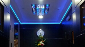 A modern lobby with a clear glass desk, a clock, and a blue-lit ceiling. - JUFFAIR GATE HOTEL (Manama)