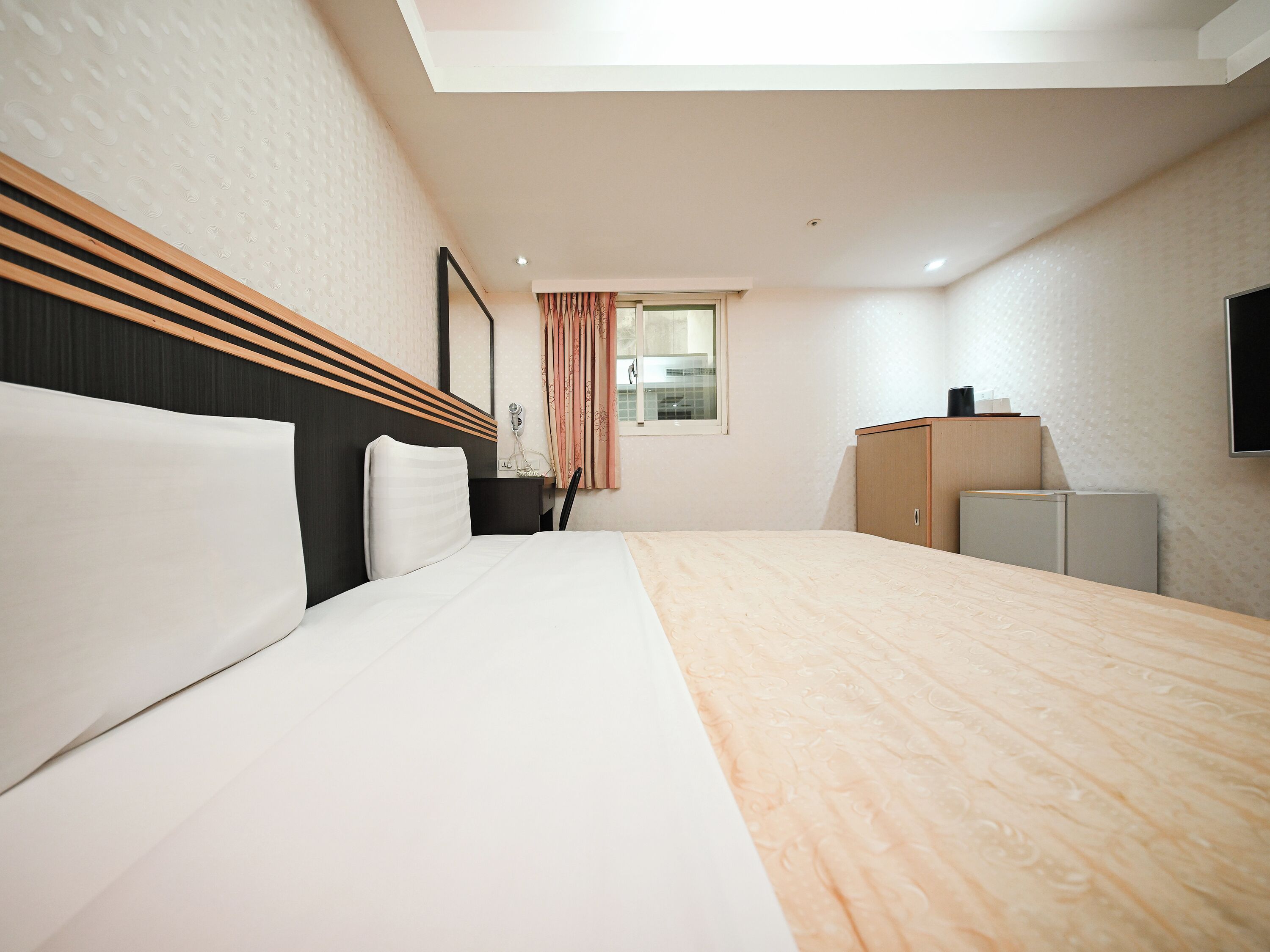 Une chambre d’hôtel équipée d’un lit, d’un bureau, d’une armoire et d’un téléviseur.