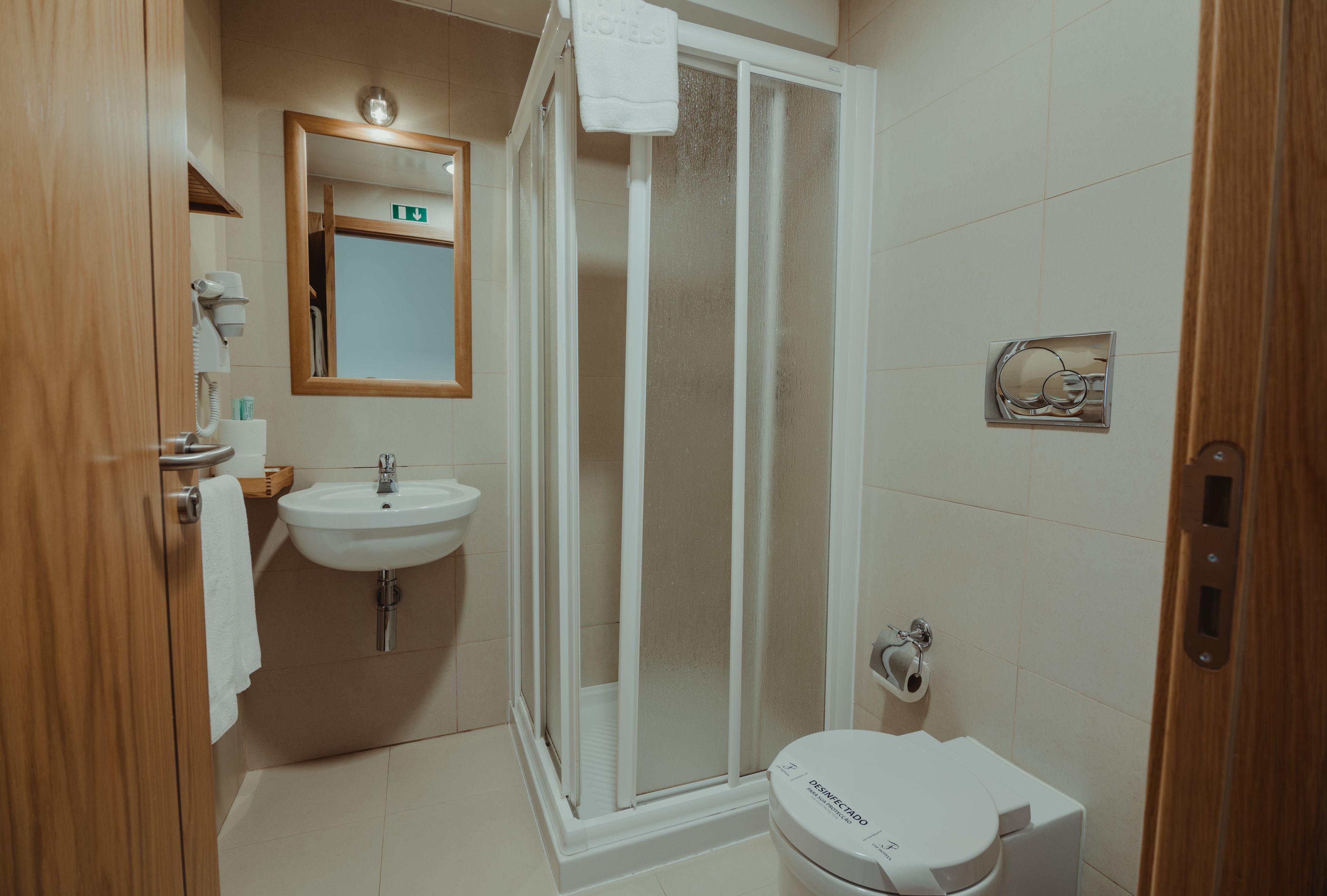 A bathroom with a sink, toilet, and glass-enclosed shower.