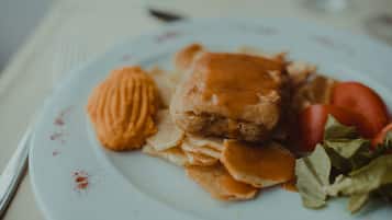 A plate with a sandwich, crackers, and a tomato.