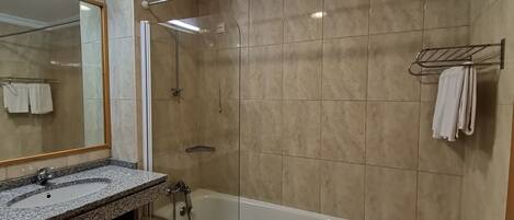 Une salle de bain moderne avec une douche à parois de verre, une baignoire sur pieds et un lavabo encastré dans un plan de travail en granit.