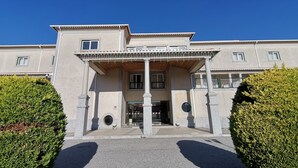 Un bâtiment à deux étages doté d’un porche, de colonnes et d’un balcon.