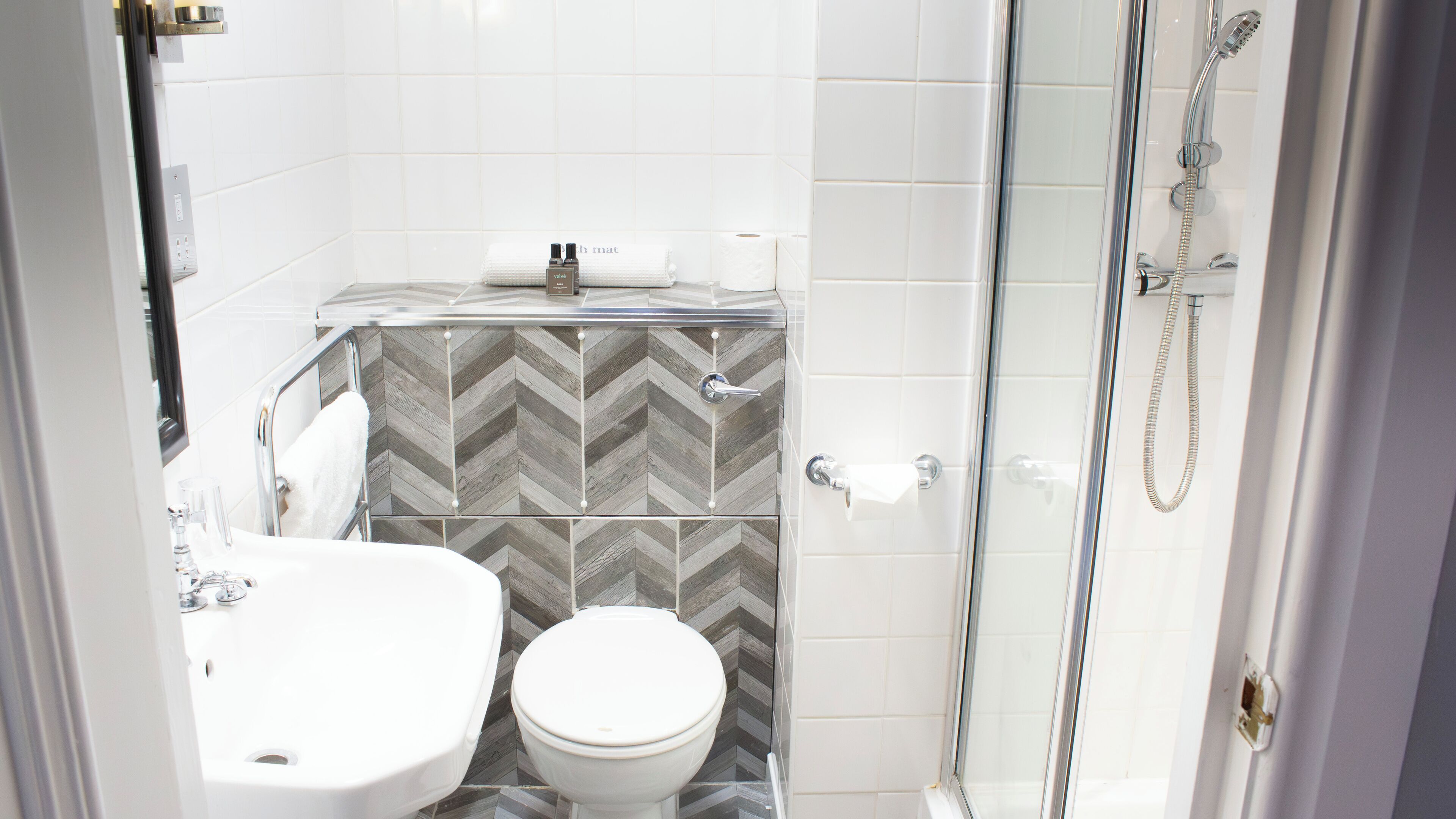 A bathroom with a toilet, sink, and shower.