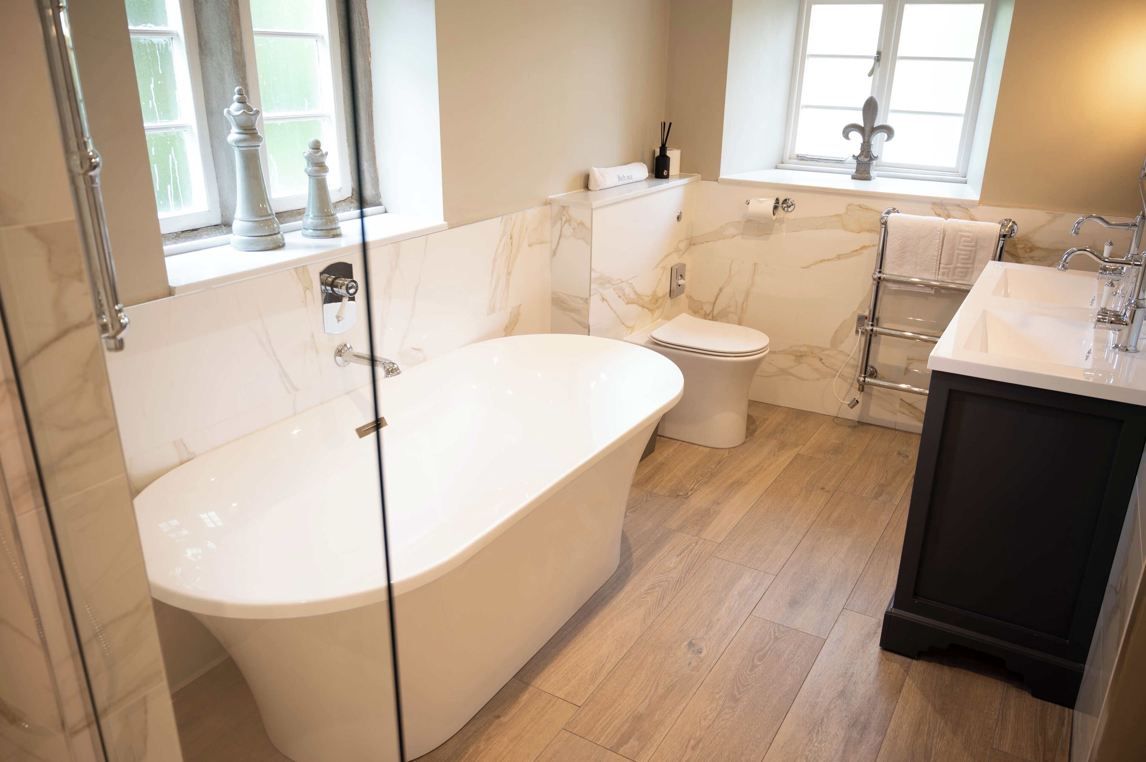 A modern bathroom with a freestanding bathtub, a toilet, and a vanity with a sink.